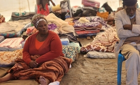 A woman waits to be profiled in a temporary shelter on Magwaveni sports field.