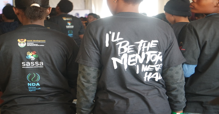 A young girl at the assembly wearing “I’ll be the mentor I never had” t-shirt.